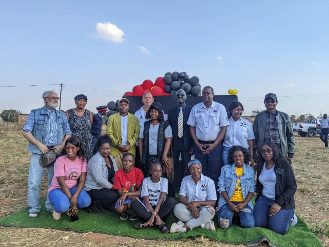 A group picture of founding members and other helping people of Twafweni smiling not the camera during the opening ceremony of the organisation.